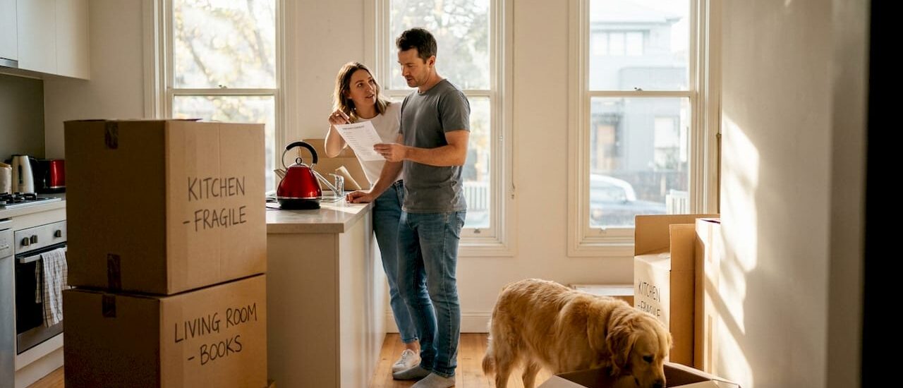 Couple checking moving checklist in unpacked Melbourne home
