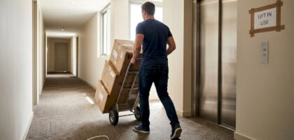 Mover with boxes in high-rise hallway