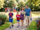 Family walking on suburban sidewalk together