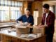 Couple packing moving boxes in apartment