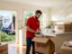 Professional mover packing boxes in living room