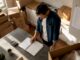 Man calculating moving costs surrounded by boxes