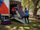 Heavy movers unloading bulky item on residential street