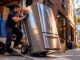 Man moving refrigerator on dolly in kitchen