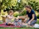Child packing toys with mother in living room
