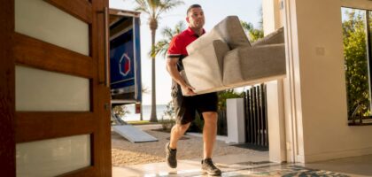 Furniture delivery worker bringing sofa inside home