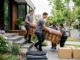 Movers loading sofa into removal truck