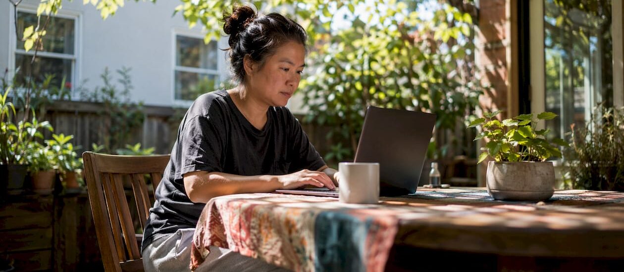 Woman entering moving details on laptop at kitchen table