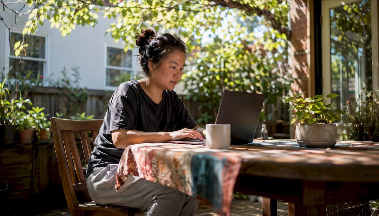Woman entering moving details on laptop at kitchen table