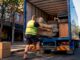 Worker loading sofa into furniture removal truck