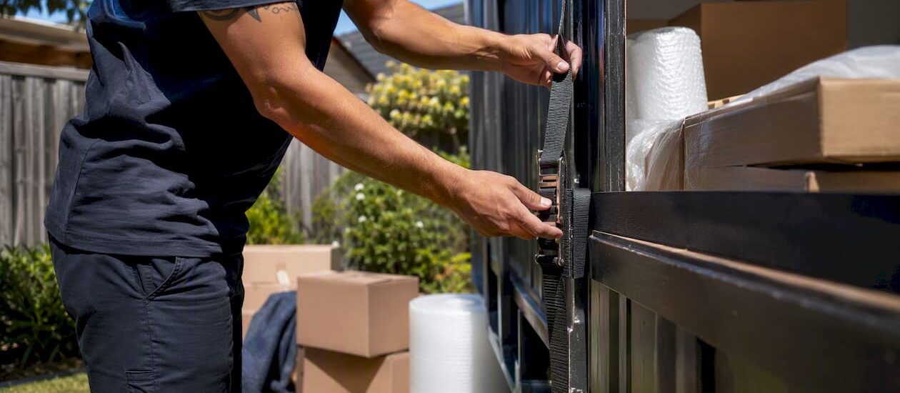 Mover securing portable container on driveway