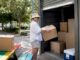 Woman loading storage boxes into unit outdoors