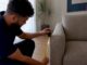 Person measuring sofa near doorway