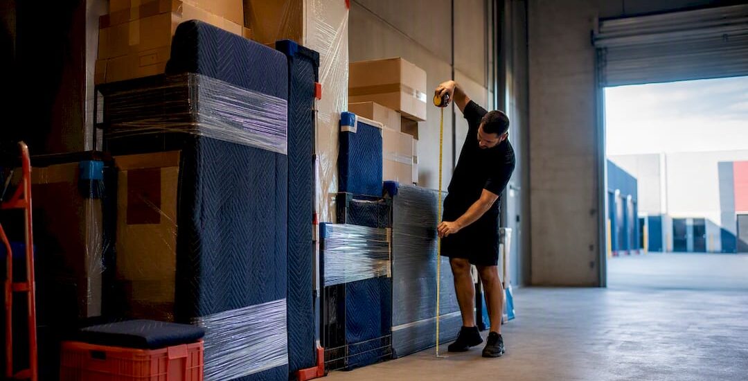 Removalist measuring household goods in warehouse