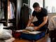 Hands packing clothes in garment bag and wardrobe box