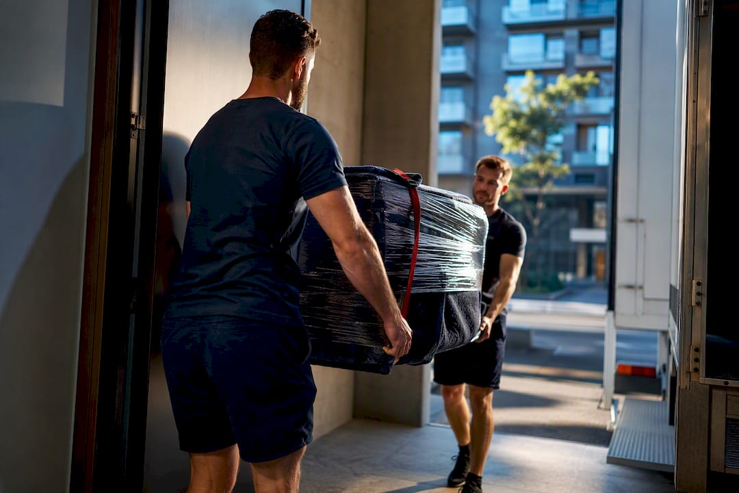 Movers transferring apartment belongings outside