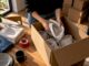 Hands reuse towels to pack moving boxes