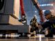 Crew securing industrial machine for relocation