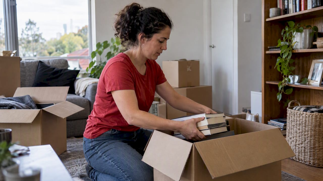 Homeowner packing books into a moving box