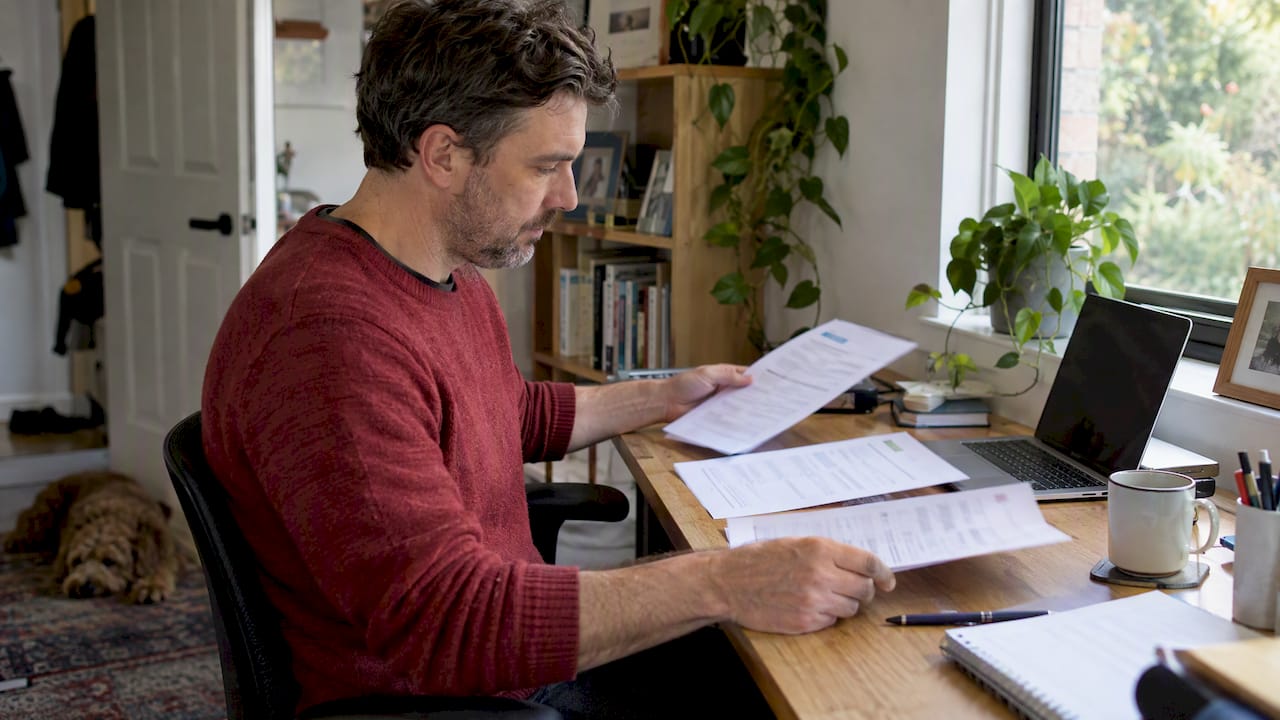 Homeowner comparing removalist quote sheets
